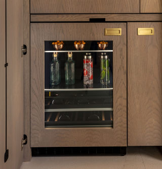 A close up of a JennAir® Beverage Center fitted with custom wooden panels. A close up of a JennAir® Beverage Center fitted with custom wooden panels.