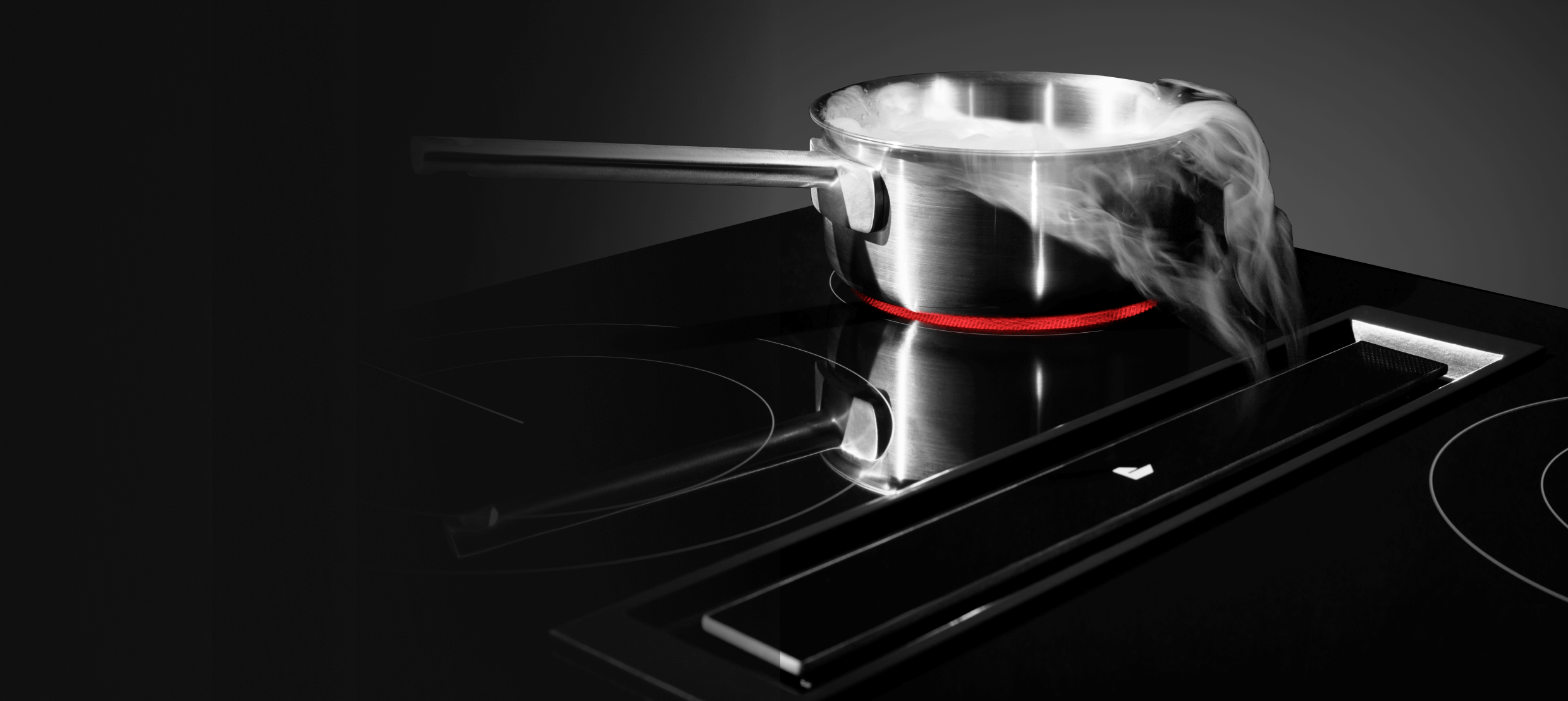 A JennAir® Downdraft Electric Cooktop pulling steam into the vent.  A JennAir® Downdraft Electric Cooktop pulling steam into the vent.