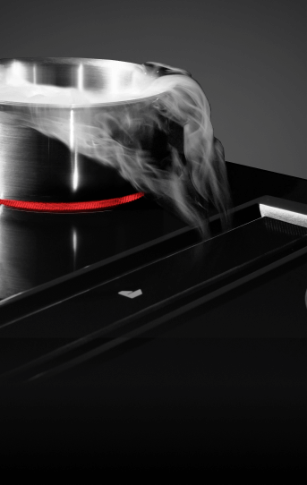 A JennAir® Downdraft Electric Cooktop pulling steam into the vent.  A JennAir® Downdraft Electric Cooktop pulling steam into the vent.