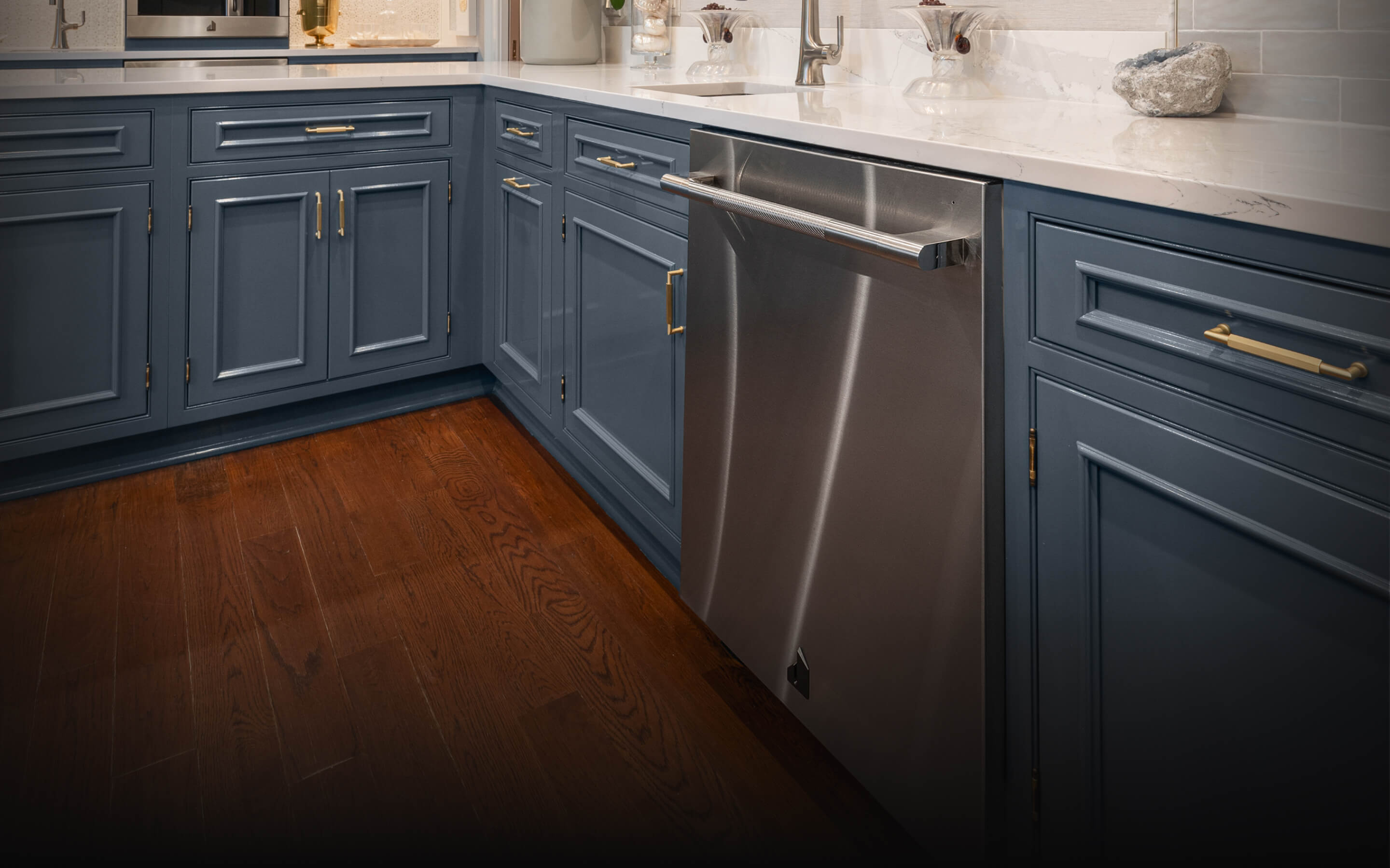 A JennAir® RISE™ Dishwasher in a kitchen with blue cabinets. A JennAir® RISE™ Dishwasher in a kitchen with blue cabinets.