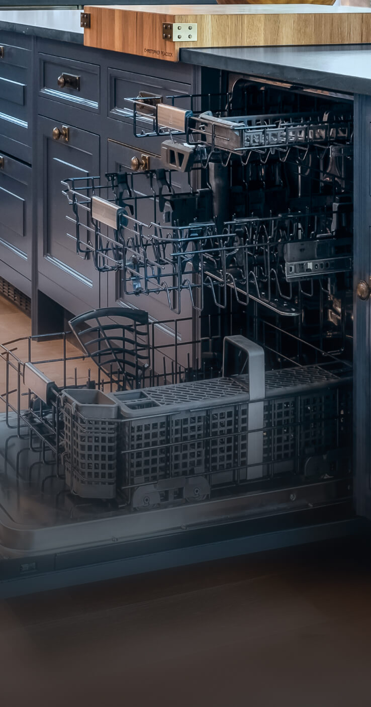 An open JennAir® Panel-Ready Dishwasher in a kitchen with blue cabinets. An open JennAir® Panel-Ready Dishwasher in a kitchen with blue cabinets.