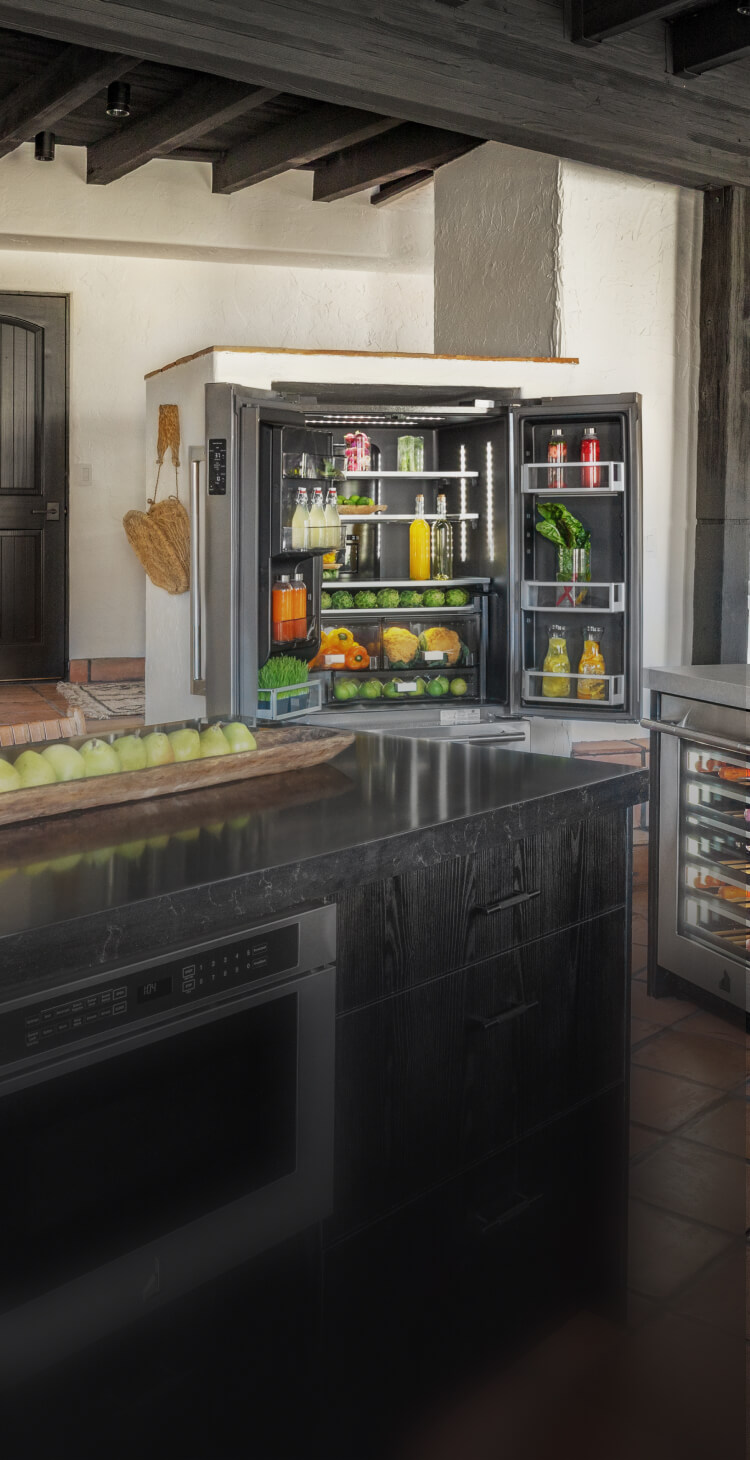 A kitchen featuring an open and stocked JennAir® French Door Freestanding Refrigerator. A kitchen featuring an open and stocked JennAir® French Door Freestanding Refrigerator.
