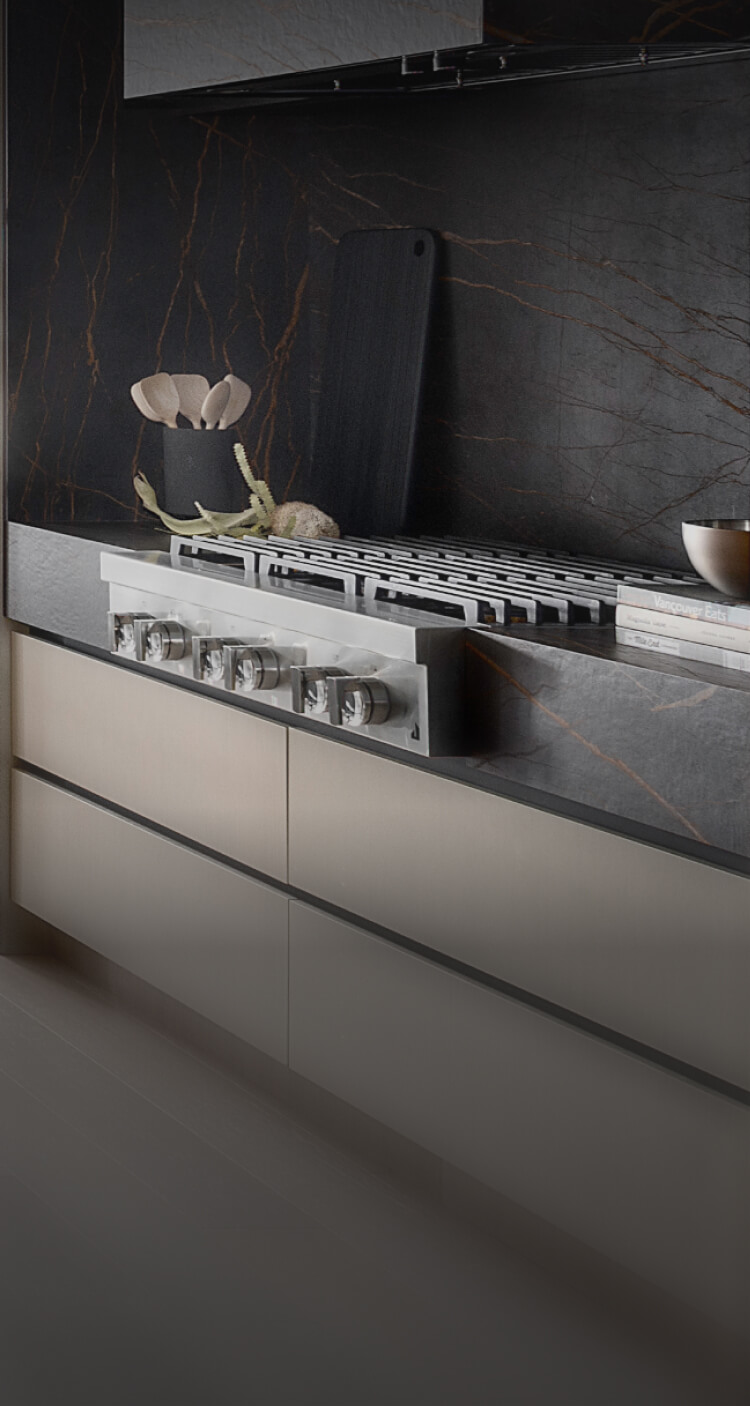 A JennAir® Gas Rangetop in a light-colored kitchen with dark accents. A JennAir® Gas Rangetop in a light-colored kitchen with dark accents.