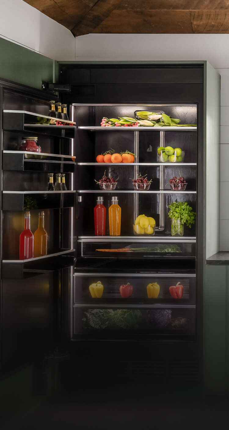A soft green kitchen fitted with panel ready and NOIR™ appliances.