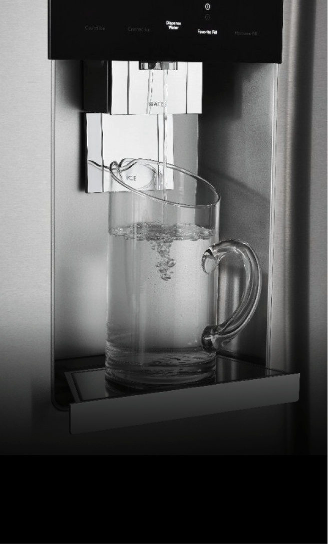 The front of a JennAir® built-in refrigerator, showing water being poured into a glass from the external dispenser. The front of a JennAir® built-in refrigerator, showing water being poured into a glass from the external dispenser.