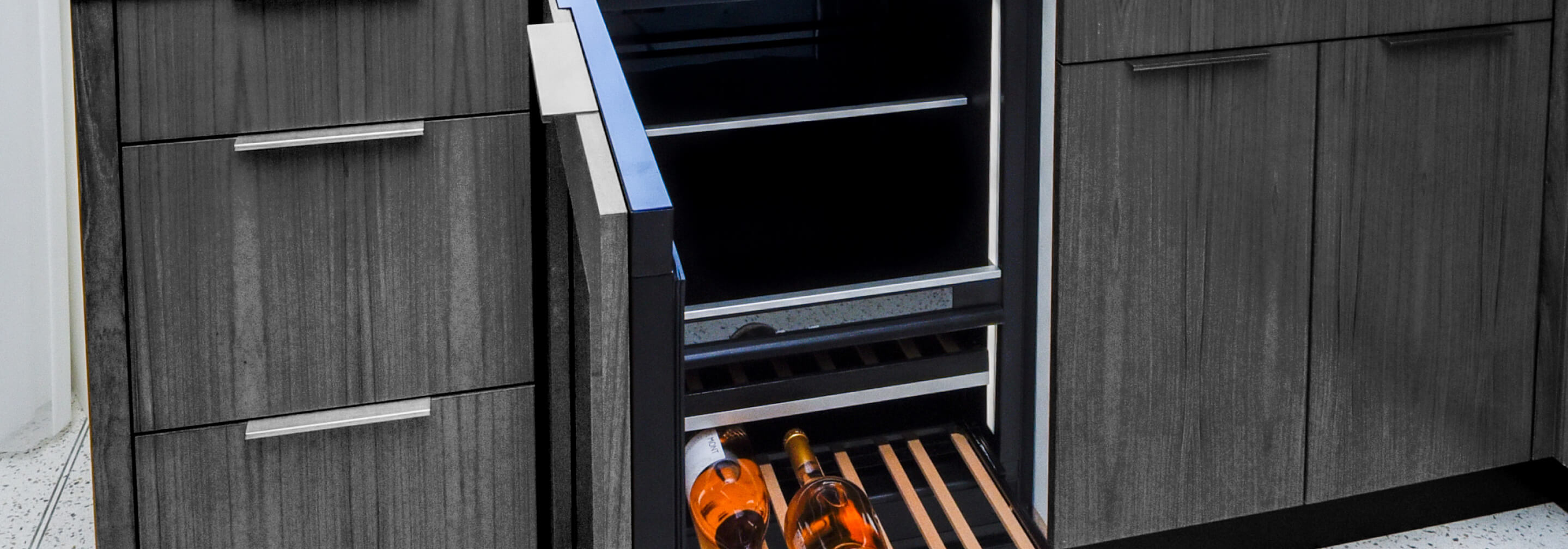 An undercounter refrigerator equipped with custom wooden panels that match the surrounding cabinetry.
