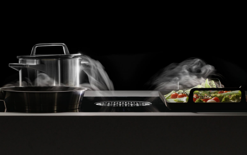 A pot with steam on a JennAir® Induction Downdraft Cooktop.