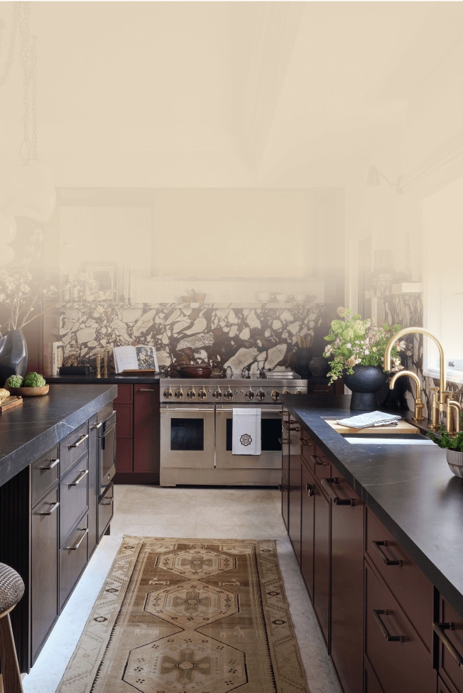 A modern kitchen with maroon cabinetry and JennAir® appliances.