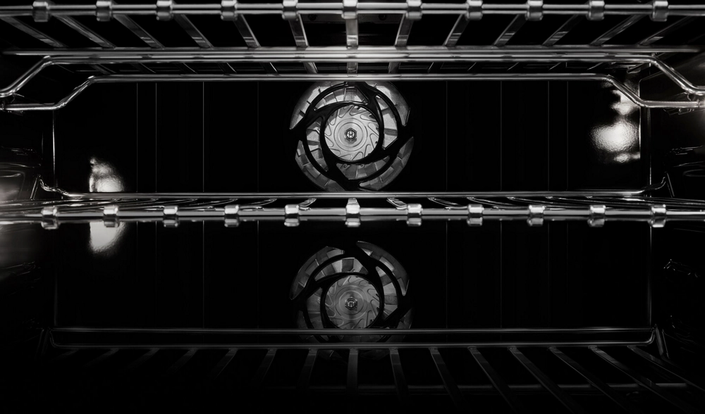 The interior of the wall oven, showing the dual convection fans and the flat tine racks.