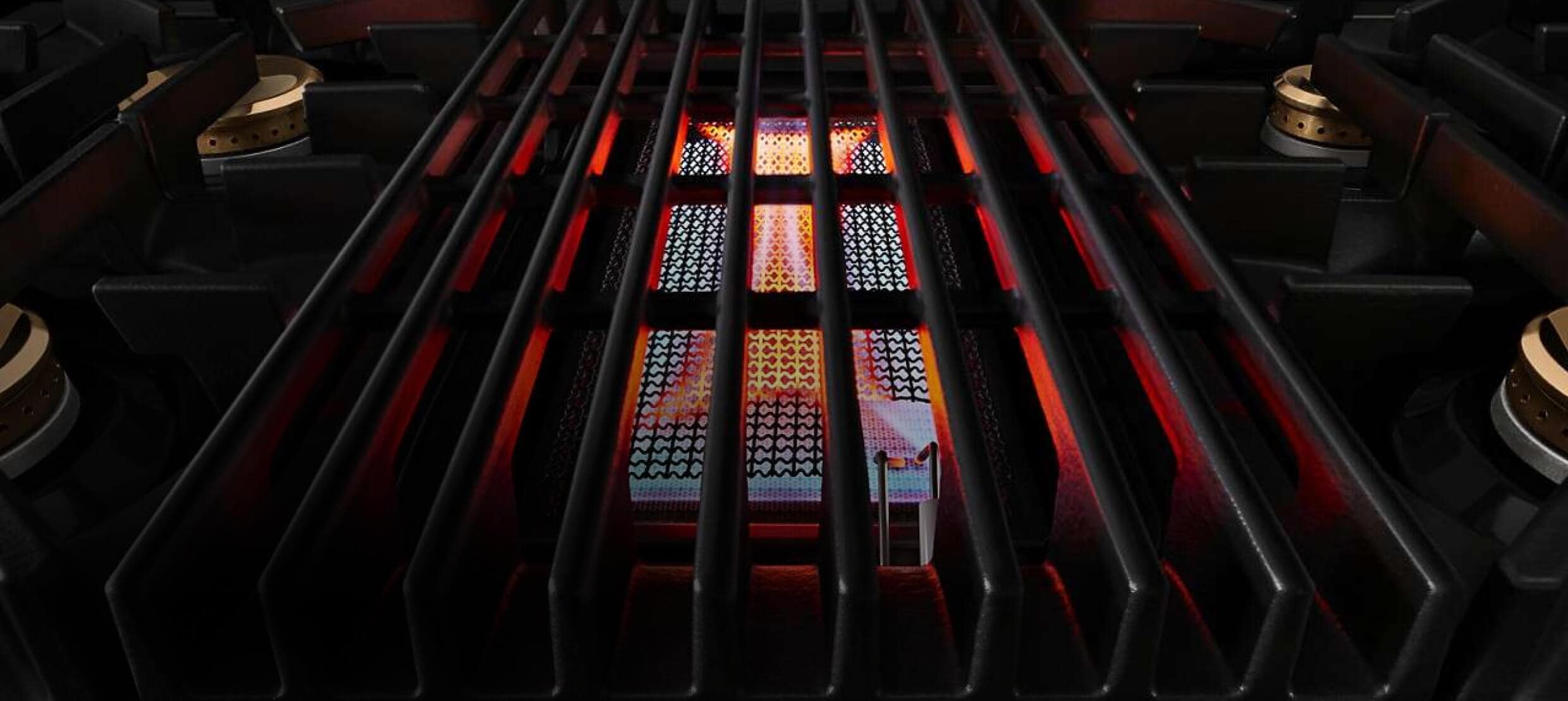 A lit grill on a JennAir® Professional-Style Range.