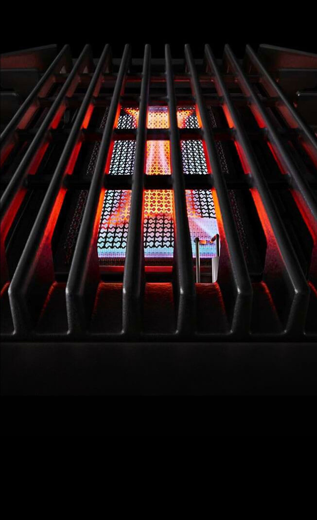 A lit grill on a JennAir® Professional-Style Range.