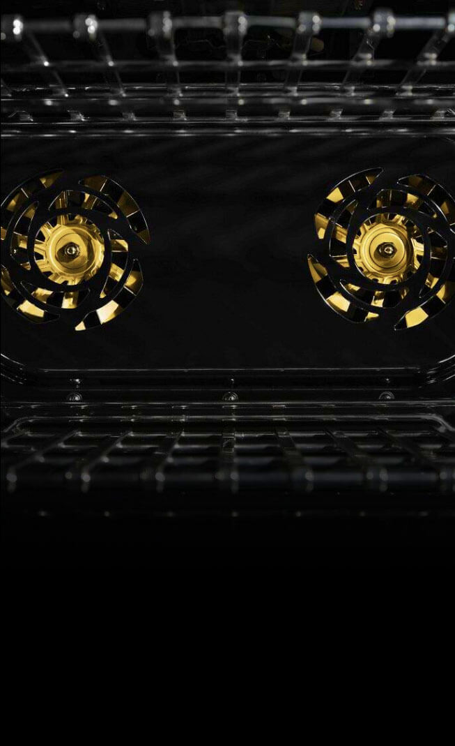 The interior of a JennAir® Professional-Style Range, with two brass fans.