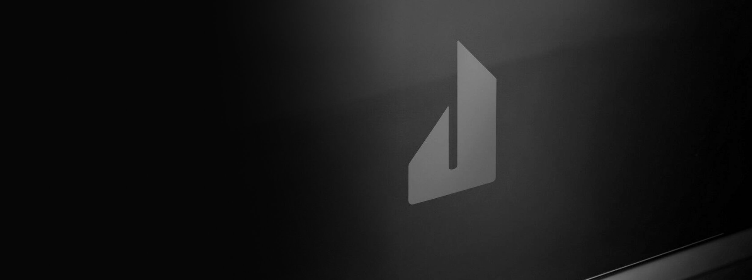 The screened Defiant J badge on the glass front of a NOIR™ Professional-Style Range.