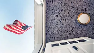 The wallpapered ceiling of the hallway showing an American flag outside of the front door.