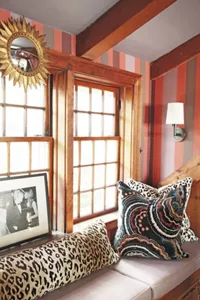 A couch with decorative pillows and windows in the Great Room. 